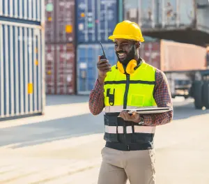 Man praat door de walkie-talkie op de kade van een haven