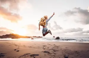 Man van achteren springt omhoog met zonsondergang