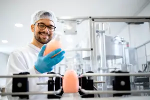 Man kijkt naar een fles gevuld met zeep in een productie omgeving