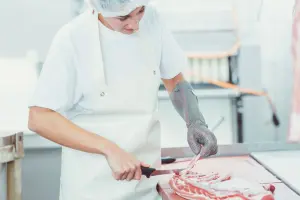 Mevrouw is professioneel het vlees aan het snijden.