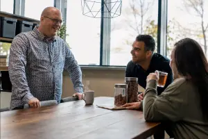 Drie medewerkers zitten samen te lunchen