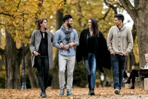 Vier medewerkers lopen samen door een bosrijke omgeving