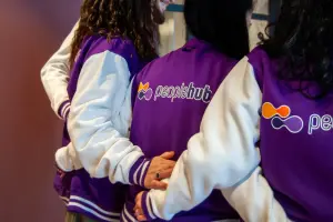 Drie medewerkers naast elkaar met peoplehub op de achterzijde