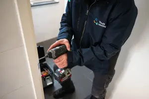 Medewerker repareert het deurkozijn