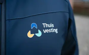 Thuisvesting logo op borst van de jas
