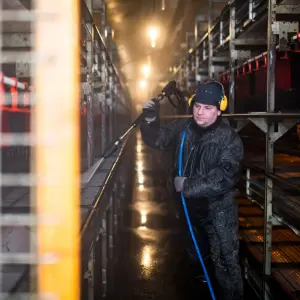 Medewerker spuit stal schoon met hogedrukreiniging