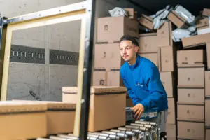 Uitzendkracht sorteert dozen in een magazijn