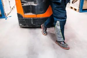 Foto van voeten van een medewerker die met een palletwagen loopt