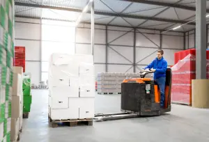 Medewerker rijd met heftruck en verplaatst en pallet