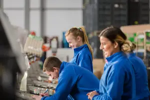 Drie medewerkers lachen tijdens hun werk